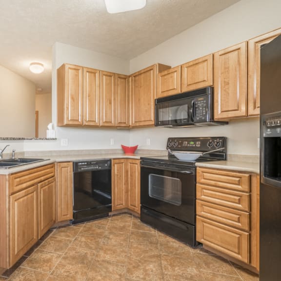 Thumbnail 7 of 12 Large kitchen with black appliances at Stone Ridge Estates townhomes in South Lincoln