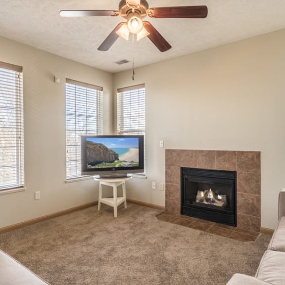 Thumbnail 4 of 12 Living room with view of fireplace, ceiling fan and large windows