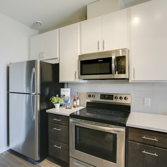 Thumbnail 4 of 11 a kitchen with stainless steel appliances and white cabinets