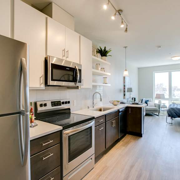 Thumbnail 3 of 11 a kitchen with stainless steel appliances and white cabinets