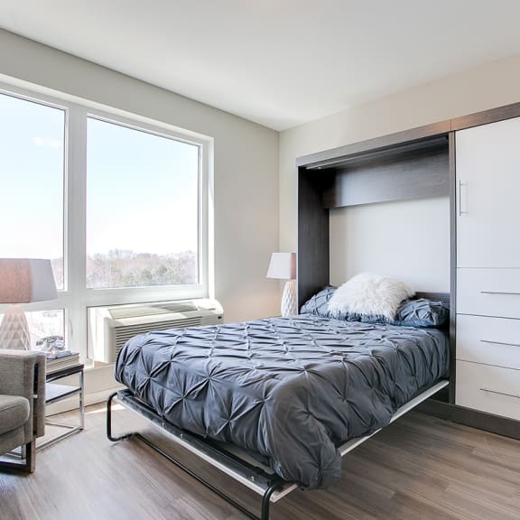Thumbnail 6 of 11 a bedroom with a bed and a large window