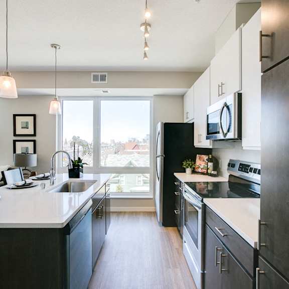Thumbnail 3 of 15 Kitchen with island and pendant lighting at The Central apartments near downtown Minneapolis MN 55408