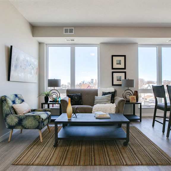 Thumbnail 8 of 15 Living room with view of downtown through large windows at The Central apartments near downtown Minneapolis MN 55408