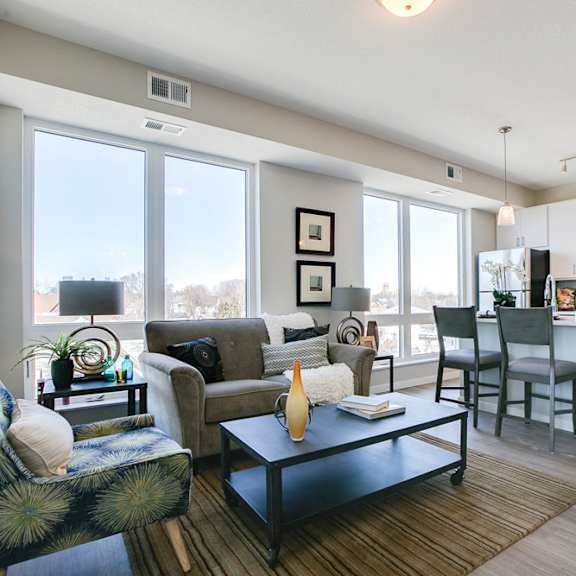 Thumbnail 9 of 15 Open floor plan with white cabinetry and hardwood-style floors at The Central apartments near downtown Minneapolis MN 55408