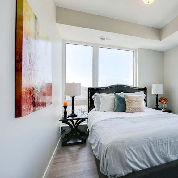 Thumbnail 12 of 15 Bedroom with large windows and high ceilings at The Central apartments near downtown Minneapolis MN 55408