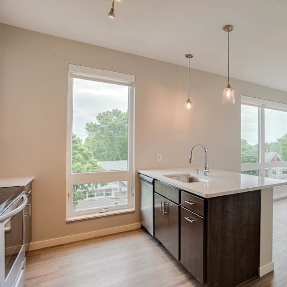 Thumbnail 3 of 5 A kitchen with a large island and pendant lights.