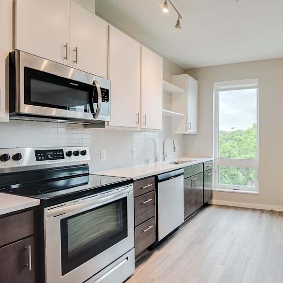 Thumbnail 3 of 6 Kitchen with upper and lower cabinets against one wall with stainless steel appliances