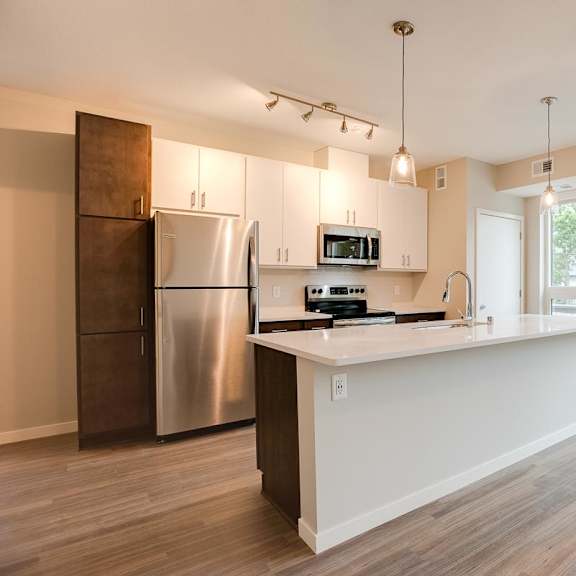 Thumbnail 3 of 4 A kitchen with a stainless steel refrigerator and microwave above the counter.