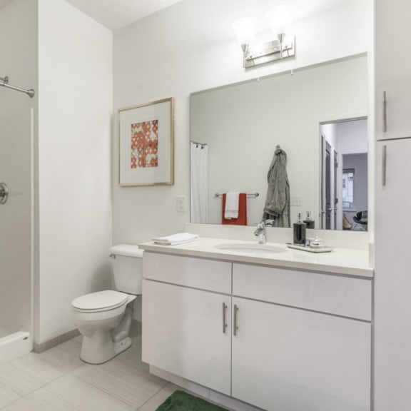 Thumbnail 8 of 9 Contemporary bathroom with white cabinetry and white quartz countertops at The Conrad