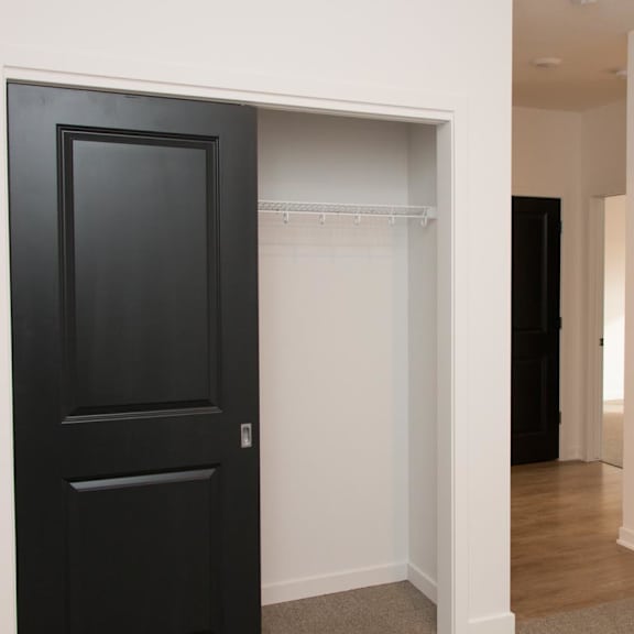 Thumbnail 6 of 8 A black door is open to a closet