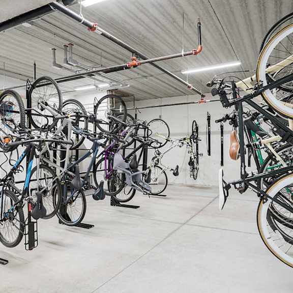 a bike locker room with multiple mounted spaces to hang bikes