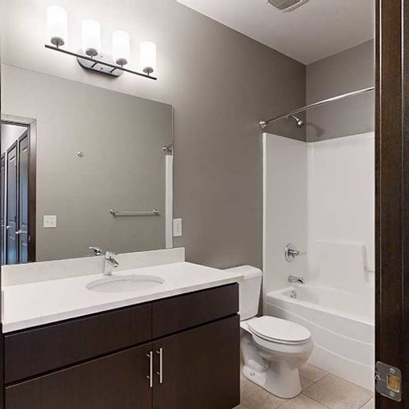 Thumbnail 19 of 21 a bathroom with a large granite countertop vanity sink sink and a combo shower and tub