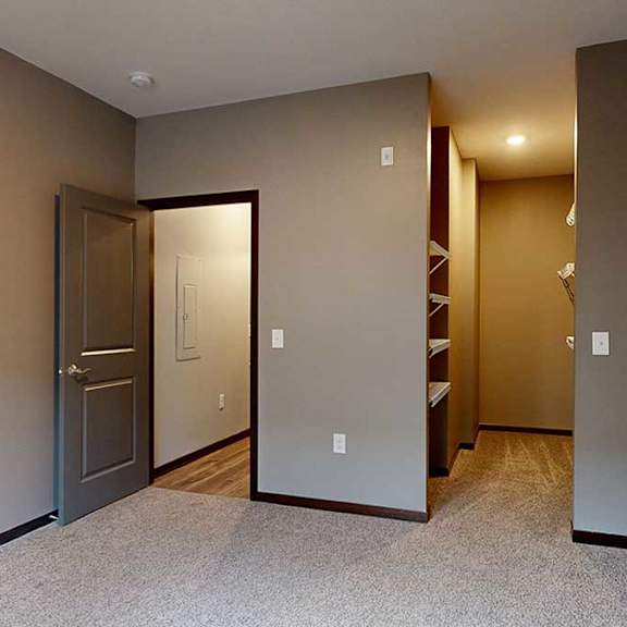 Thumbnail 15 of 21 a bedroom with a walk-in closet with built-in shelving and hanging space
