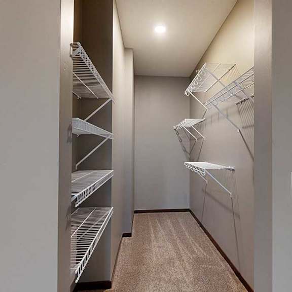 Thumbnail 16 of 21 a long, narrow walk-in closet with shelving and a carpeted floor
