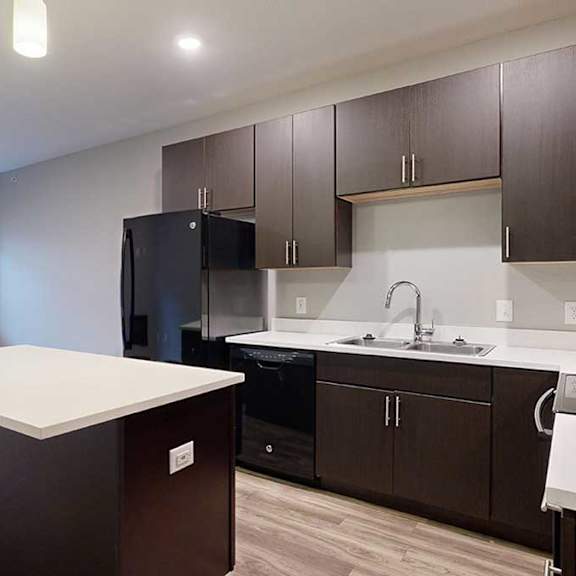Thumbnail 5 of 21 a kitchen with dark brown cabinets and a white granite island