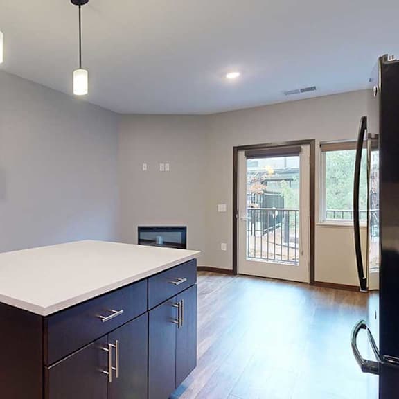 Thumbnail 7 of 21 a granite countertop kitchen island in front of a living room and a hallway
