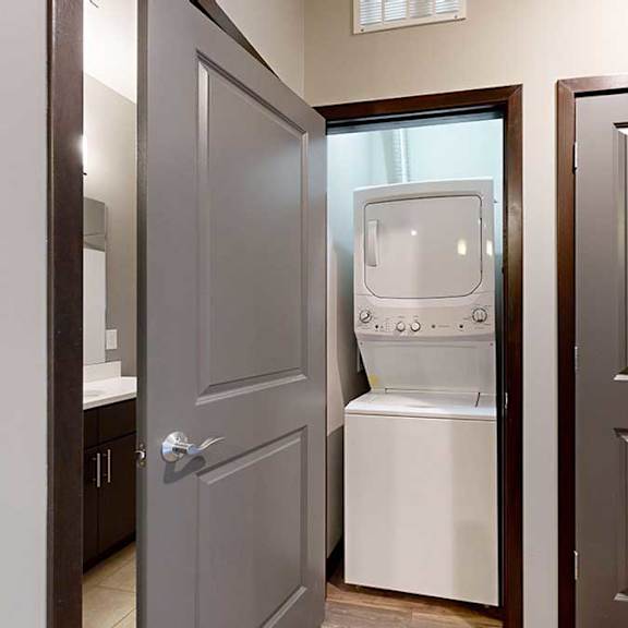 Thumbnail 21 of 21 a  laundry room in the hallway with a fullsize stackable washer and dryer