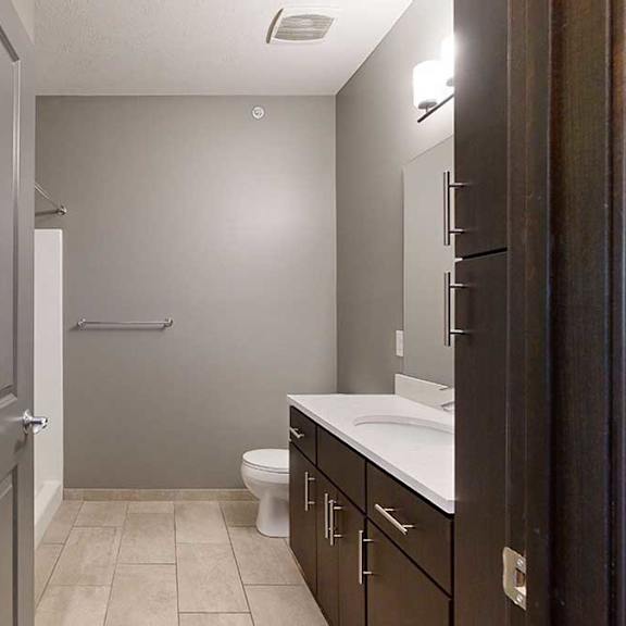 Thumbnail 15 of 17 a bathroom with a granite vanity sink and a walk-in shower