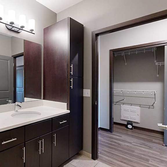 Thumbnail 16 of 17 a bathroom with a white granite countertop and dark brown cabinets