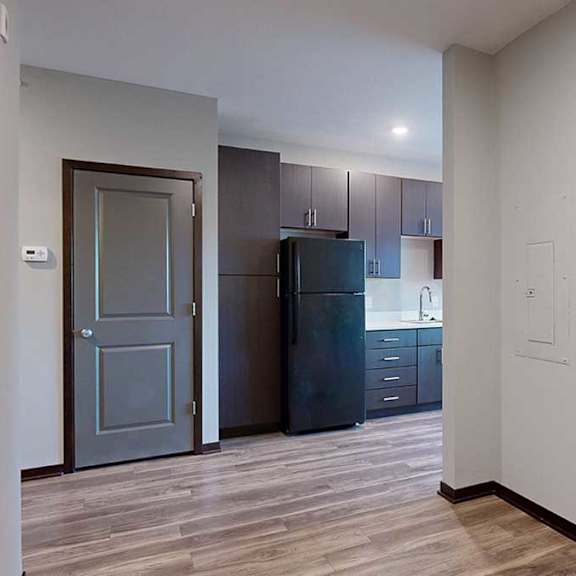 Thumbnail 4 of 17 a view of the kitchen with dark cabinets from the sleeping area