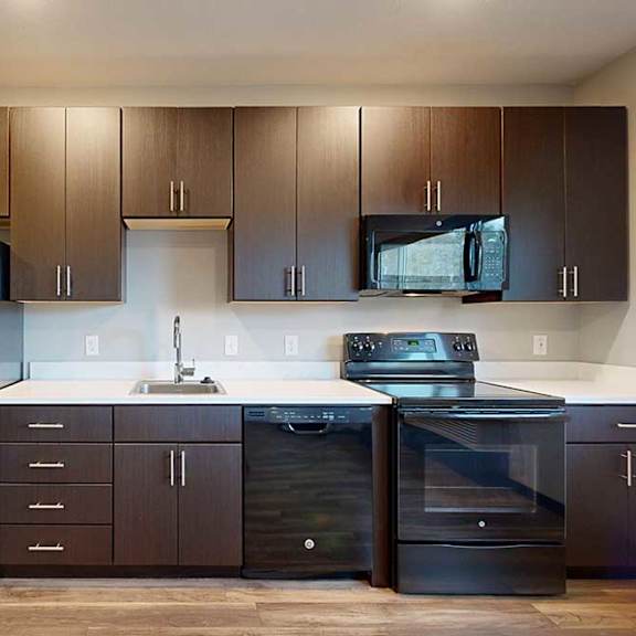 Thumbnail 6 of 17 a kitchen with dark brown cabinets, white granite countertops, and black appliances