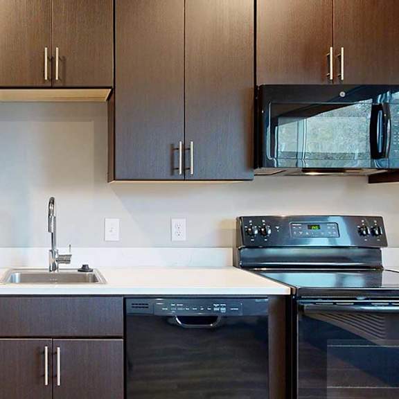 Thumbnail 7 of 17 a kitchen with dark brown cabinets and black appliances