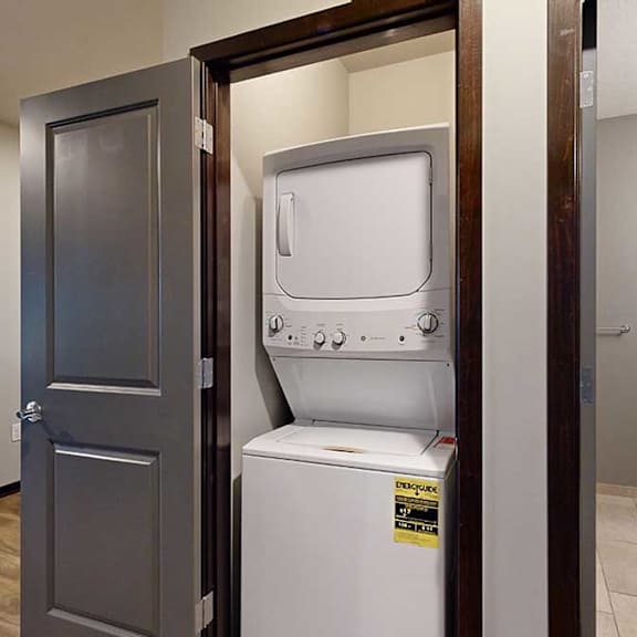 Thumbnail 14 of 17 a laundry closet with a stackable full sized washer and dryer