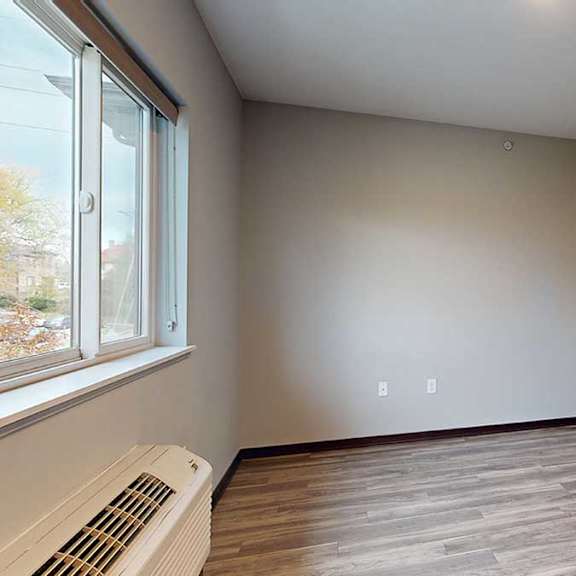 Thumbnail 9 of 17 a living area with a window and hardwood floors