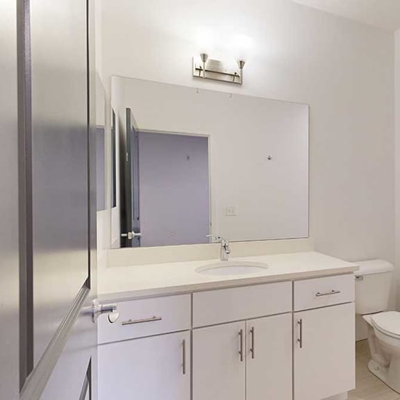 Thumbnail 25 of 28 an attached bathroom with a granite vanity sink and a walk-in shower