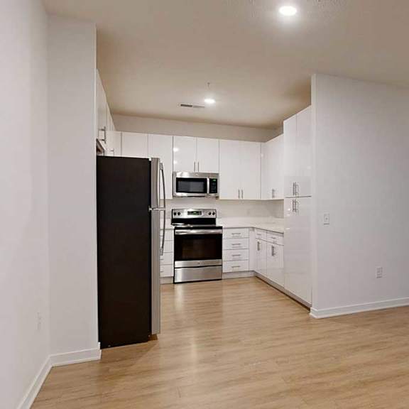 Thumbnail 20 of 28 a modern kitchen with light cabinets and stainless steel appliances next to a dining area