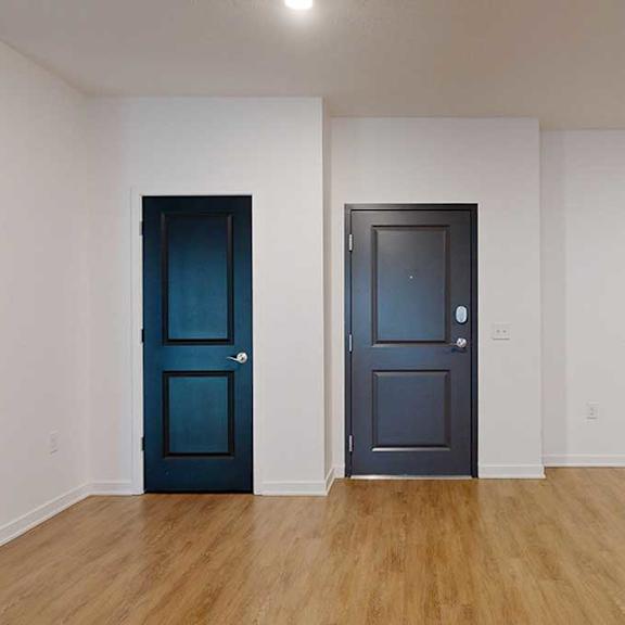 Thumbnail 2 of 28 the front door to the 2-bedroom Metz floorplan in a living room with hardwood flooring