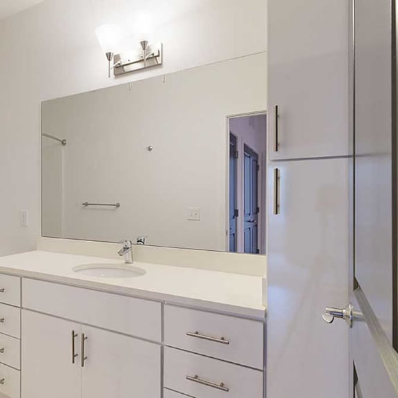 Thumbnail 4 of 28 a bathroom with a granite vanity sink, mirror, and white cabinets