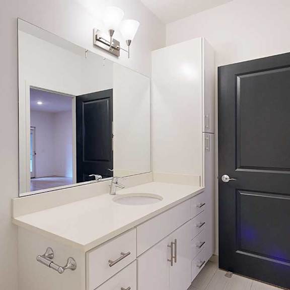 Thumbnail 6 of 28 a bathroom with a white granite vanity sink and a tall white storage cabinet