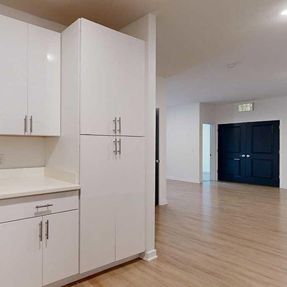 Thumbnail 19 of 28 a kitchen with white cabinets and a dining area in the background