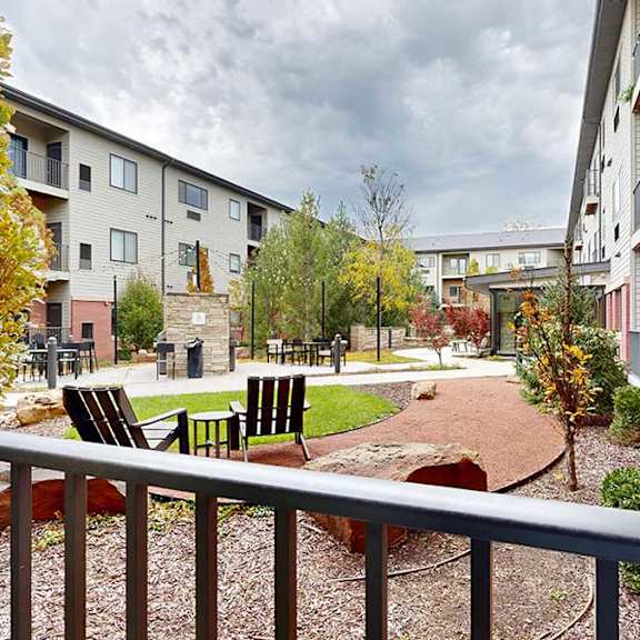 Thumbnail 13 of 28 a patio that overlooks a courtyard with a table and chairs and walking path