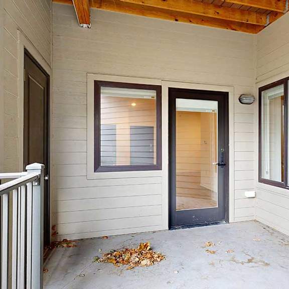 Thumbnail 14 of 28 a patio with a glass door and a two windows