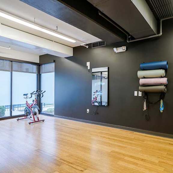 a yoga and spin studio with wooden floors and large windows
