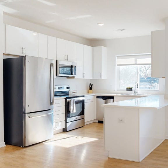 Thumbnail 5 of 15 Furnished apartment kitchen with white finish style and stainless steel appliances
