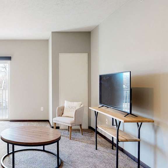 Thumbnail 2 of 9 Furnished apartment living room with sofa, lounging chair, and coffee table