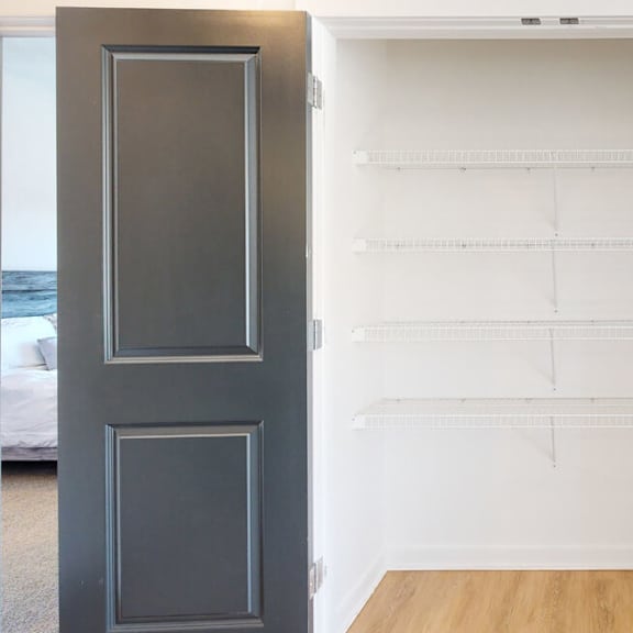 Thumbnail 14 of 18 A coat closet with double doors and white wire shelving