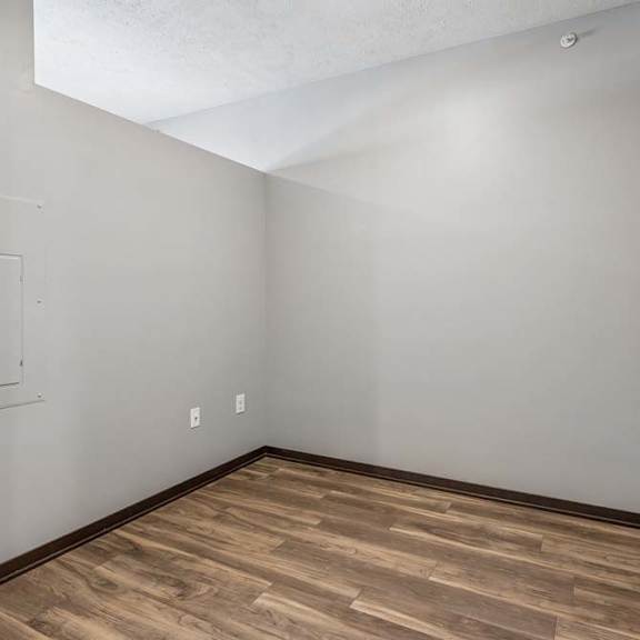 Thumbnail 8 of 15 Flexible studio apartment nook with wood-style flooring, neutral walls, and an open layout for added living or workspace.