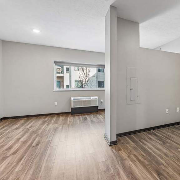 Thumbnail 11 of 15 Studio apartment with a flexible alcove, wood-style flooring, and an open layout leading to the bright living area.