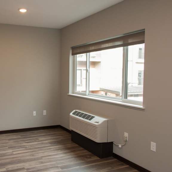 Thumbnail 4 of 7 A room with a window and a wall hvac unit