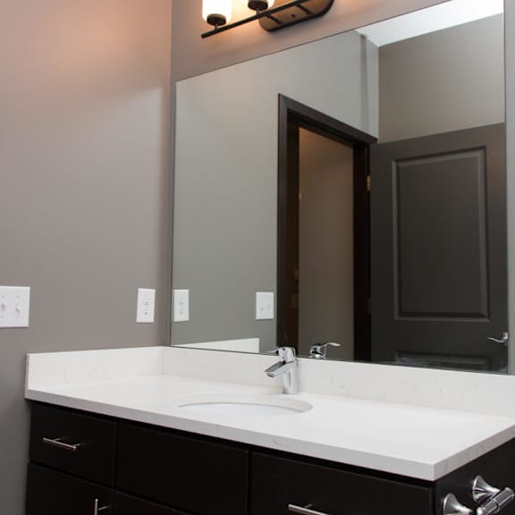 Thumbnail 7 of 7 A bathroom with a white sink and a mirror above it.