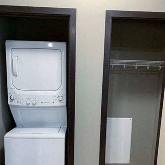 Thumbnail 16 of 21 Stacked washer and dryer in closet next to extra storage closet