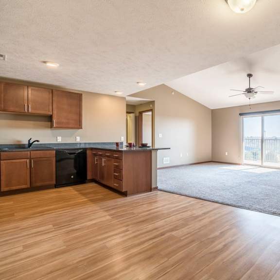 Thumbnail 3 of 24 A spacious kitchen with wooden floors and a ceiling fan.