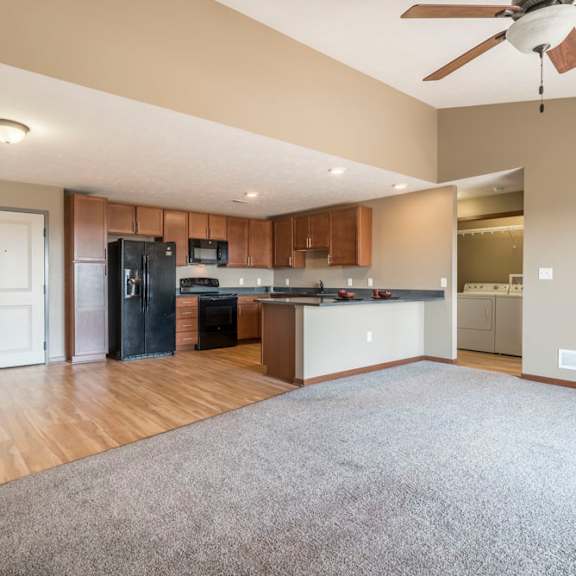 Thumbnail 5 of 24 A spacious kitchen with wooden floors and a ceiling fan.