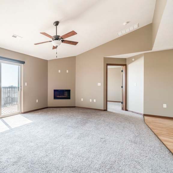 Thumbnail 6 of 24 A spacious living room with a fireplace and sliding glass doors.