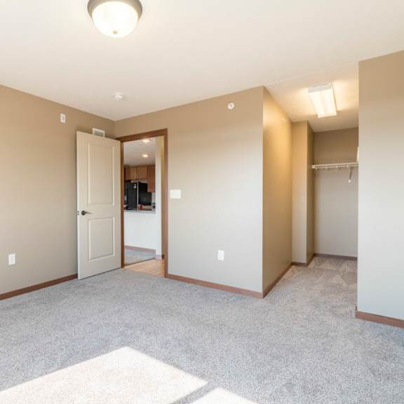 Thumbnail 13 of 24 A spacious room with a carpeted floor and a doorway leading to another room.