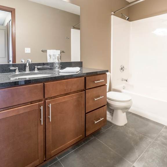 Thumbnail 15 of 24 Bathroom with granite countertops and tile floors at The Flats at 84 in southeast Lincoln NE 68516